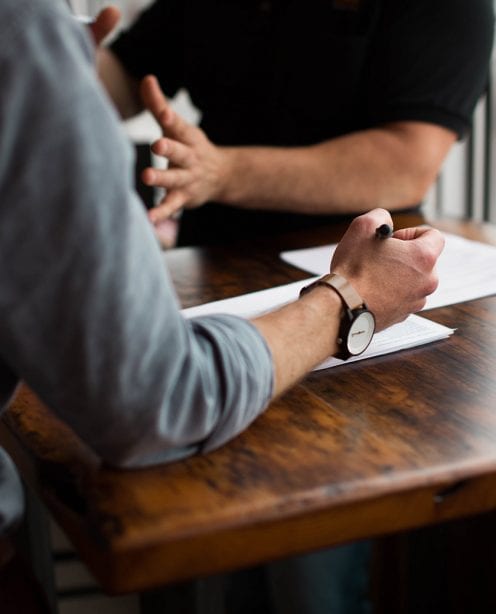 Man in blue shirt with stylish watch taking handwritten notes