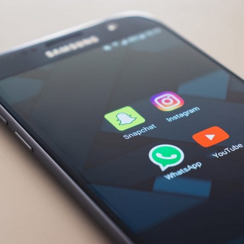 A Samsung smartphone, with Snapchat, Instagram, WhatsApp and YouTube visible