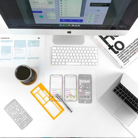 White desk with various objects used for UX design