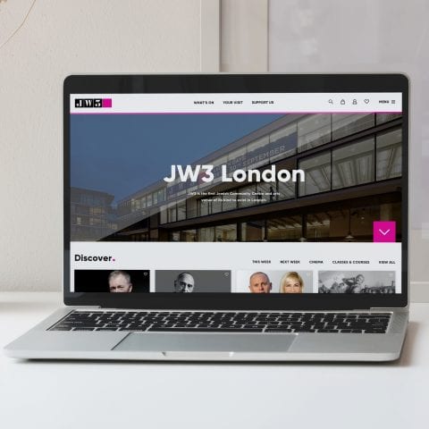 jw3 homepage loaded on a laptop placed on a desk