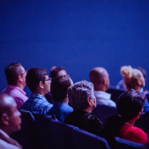 A Cinema with people sat watching a screen