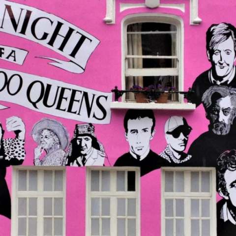 The exterior of Chelsea Art Club painted pink with art work of people and the text 'A Night of a 1000 Queens'