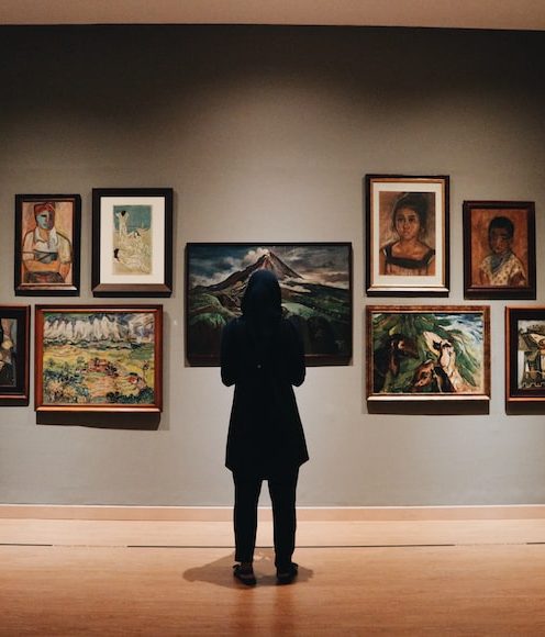 A woman looking at paintings in a gallery